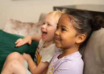 two young children sitting on a couch laughing at The Clearing at ONE28, Olathe, Kansas